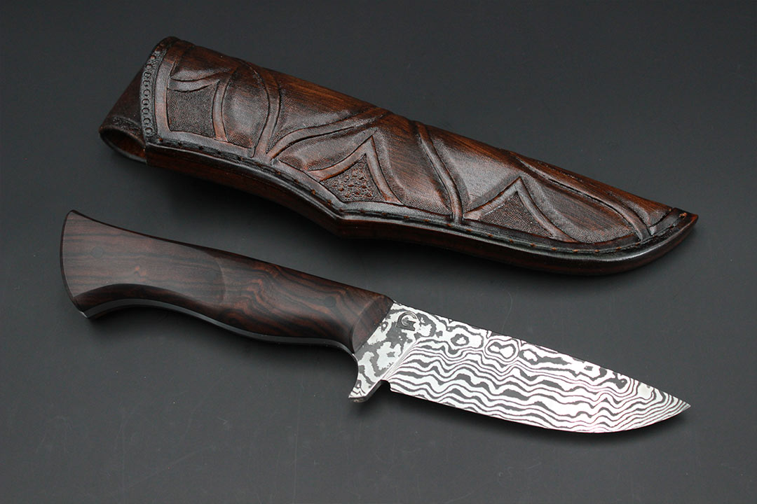 Handgeschmiedetes Jagdmesser aus Damaststahl mit Griff aus Wüsteneisenholz mit dazu passender Lederscheide